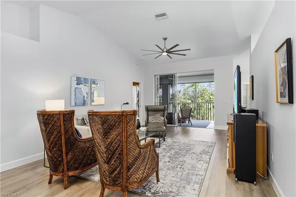 a living room with furniture a flat screen tv and a large window