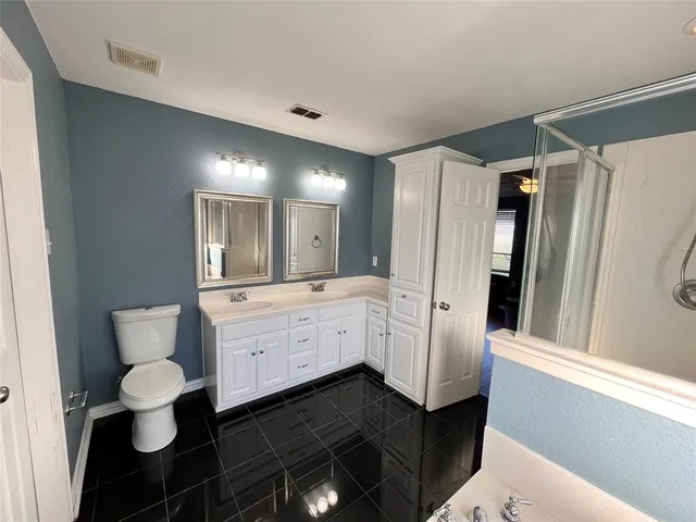 a bathroom with a double vanity sink a mirror and a bathtub
