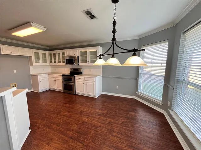 a kitchen with wooden floors and appliances