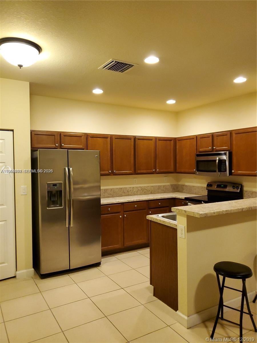 3353 West 91st Terrace Hialeah, FL 33018 - Photo 13 of 21 a kitchen with stainless steel appliances granite countertop a refrigerator a stove a sink and a microwave