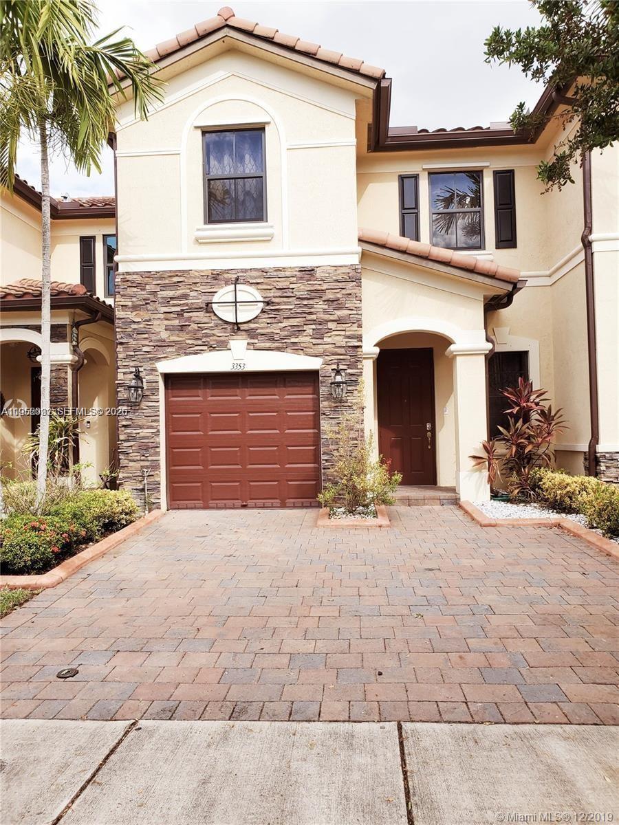 3353 West 91st Terrace Hialeah, FL 33018 - Photo 3 of 21 a front view of a house with a yard and a garage