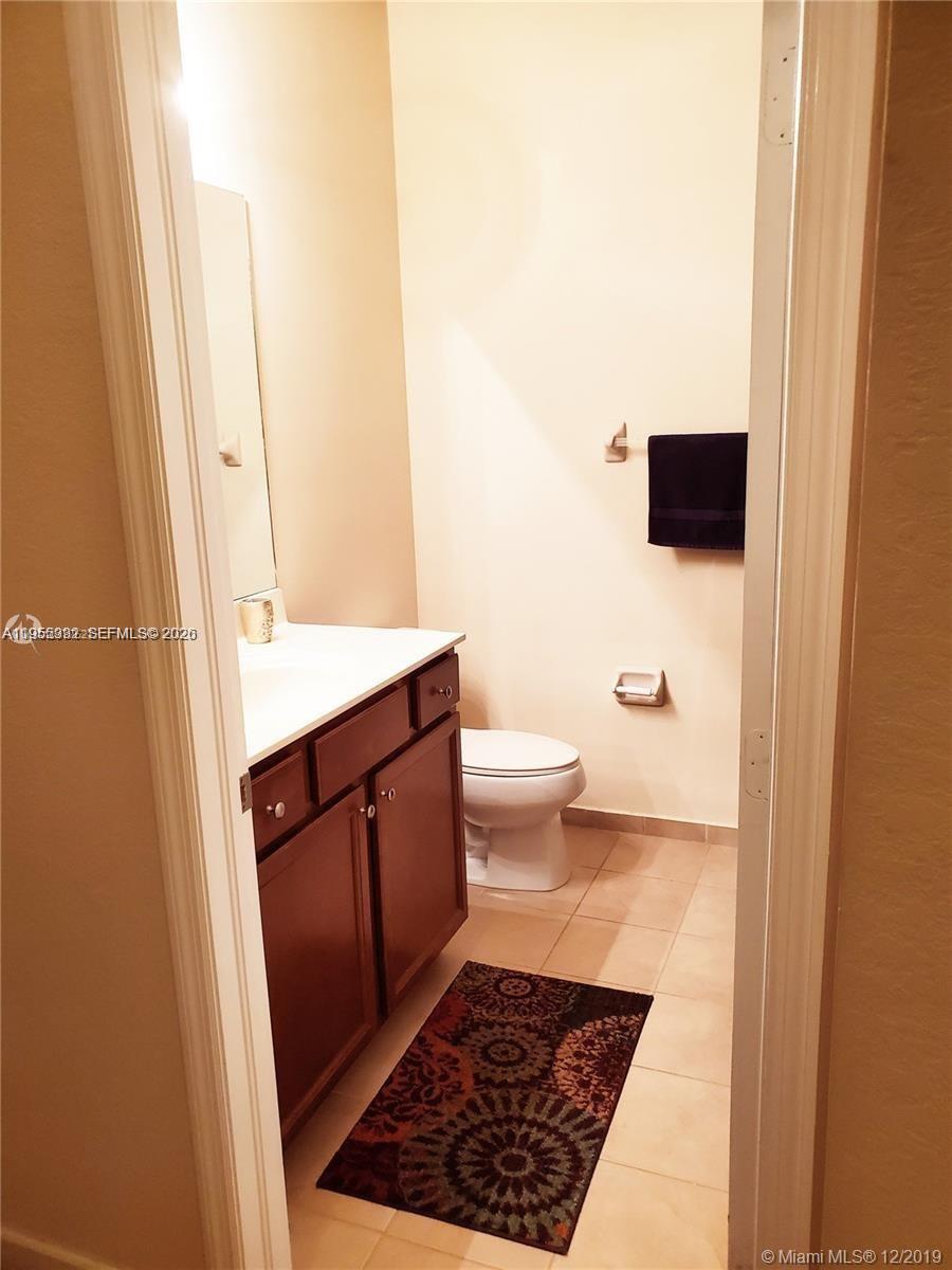 3353 West 91st Terrace Hialeah, FL 33018 - Photo 8 of 21 a bathroom with a sink a toilet a mirror and vanity