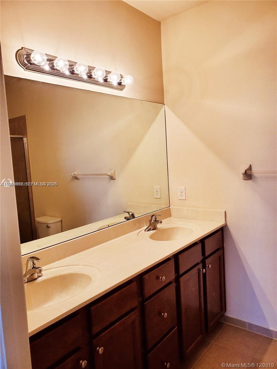 3353 West 91st Terrace Hialeah, FL 33018 - Photo 9 of 21 a bathroom with a sink and a mirror