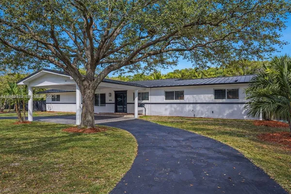 a front view of a house with a yard and trees