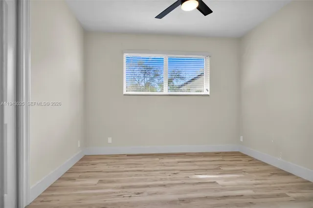 an empty room with wooden floor and window