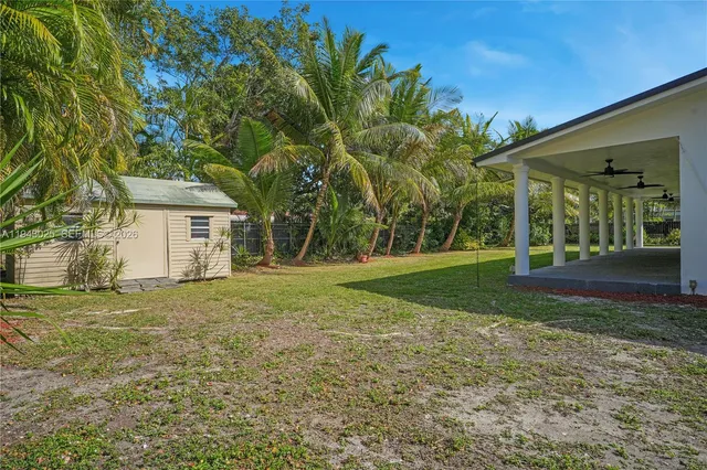 a view of a house with backyard and trees