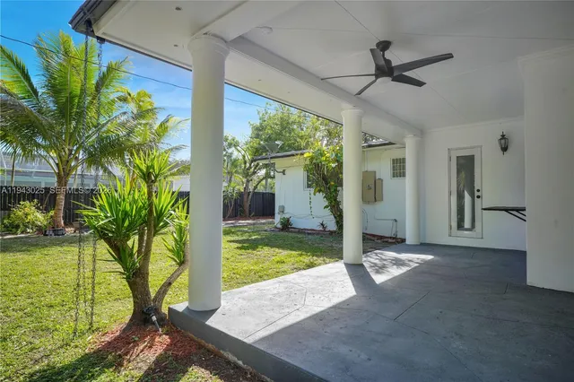 a view of a porch in front of a house with a big yard