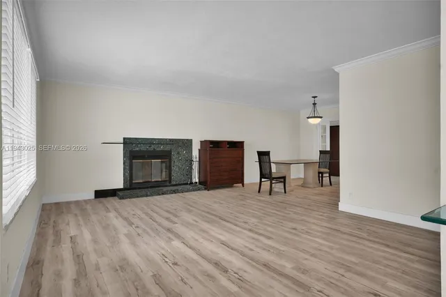 a view of empty room with wooden floor and fireplace