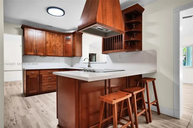 a kitchen with stainless steel appliances kitchen island a table chairs in it and wooden floors