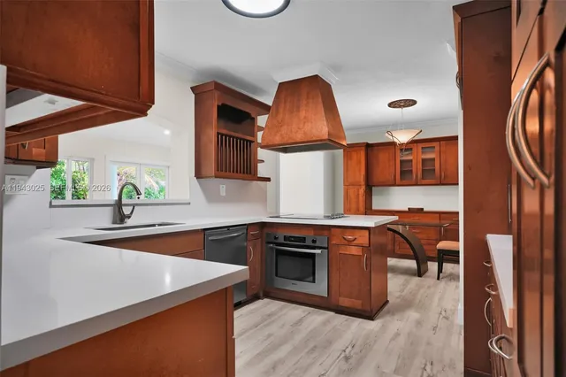 a kitchen with stainless steel appliances granite countertop a sink a stove and a wooden floors