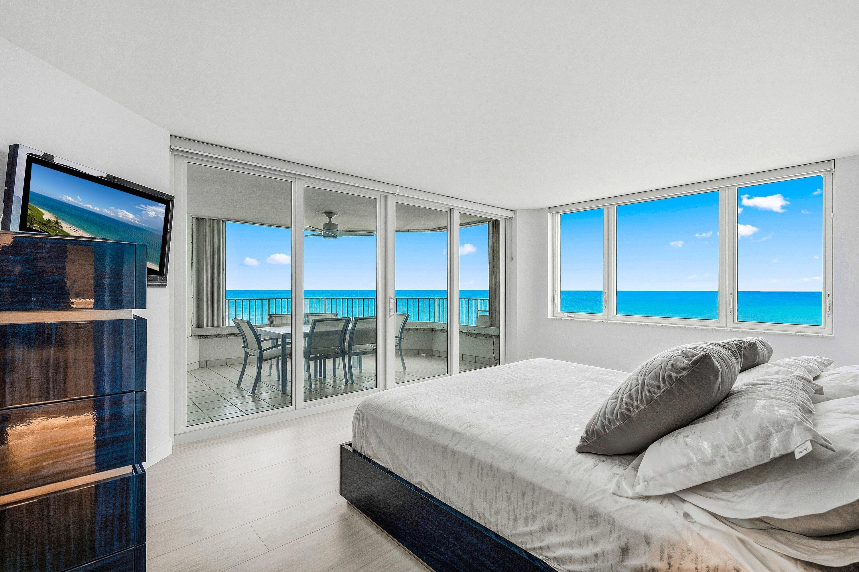 500 South Ocean Boulevard, Unit 801 Boca Raton, FL 33432 - Photo 13 of 61 a bedroom with a bed and a large window with balcony view