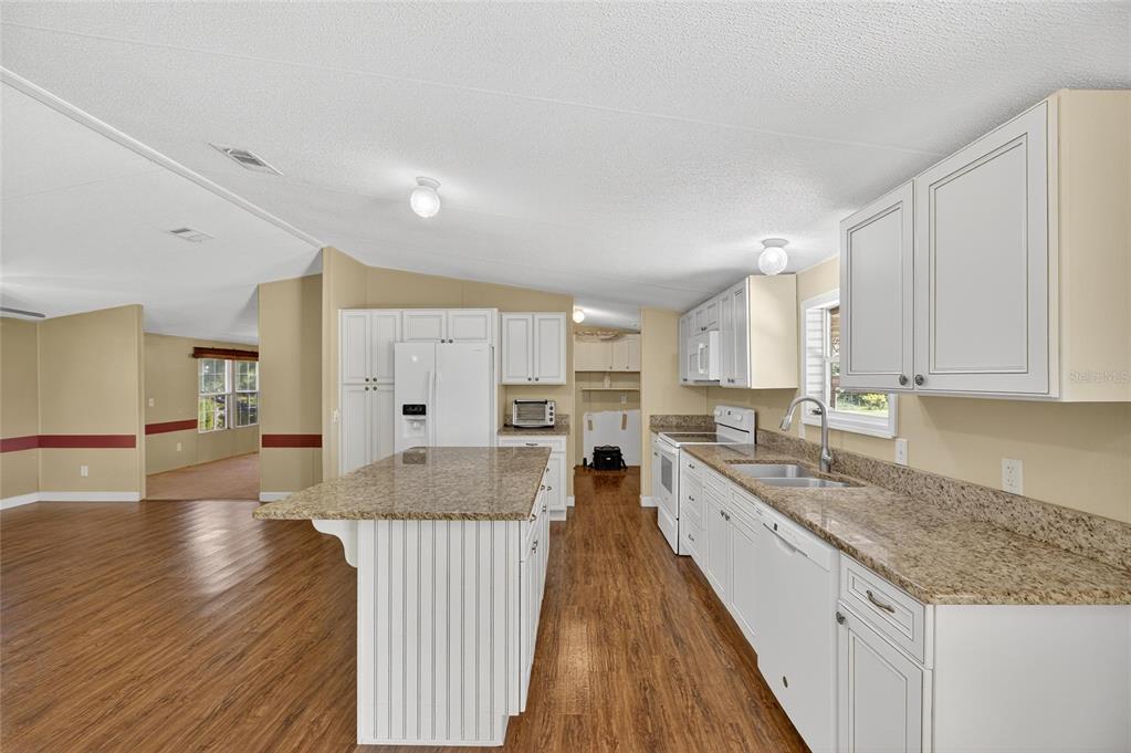 4416 Pippin Road Plant City, FL 33567 - Photo 20 of 86 a large kitchen with stainless steel appliances granite countertop a lot of counter space and wooden floors