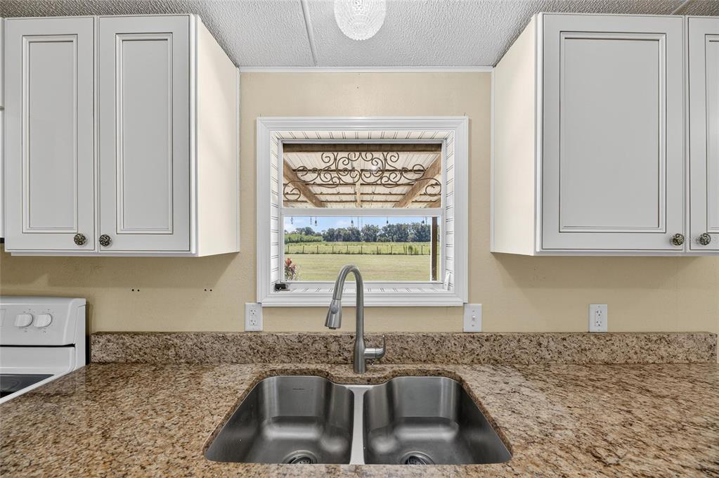 4416 Pippin Road Plant City, FL 33567 - Photo 23 of 86 a kitchen with granite countertop a sink and a stove