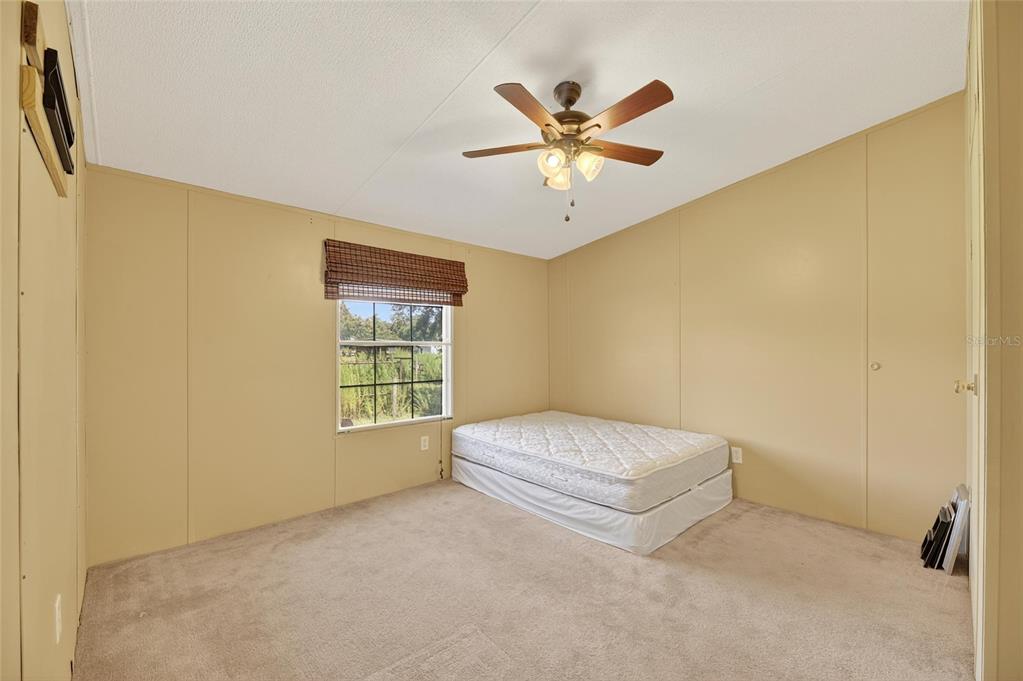 4416 Pippin Road Plant City, FL 33567 - Photo 42 of 86 a spacious bedroom with a bed and a chandelier