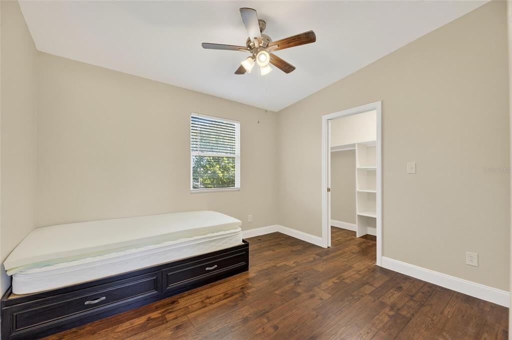 4416 Pippin Road Plant City, FL 33567 - Photo 59 of 86 an empty room with wooden floor and a ceiling fan