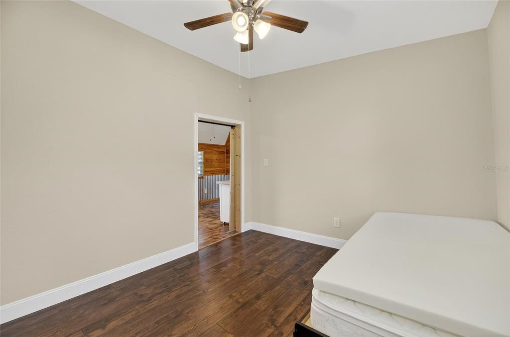 4416 Pippin Road Plant City, FL 33567 - Photo 61 of 86 an empty room with wooden floor and fan