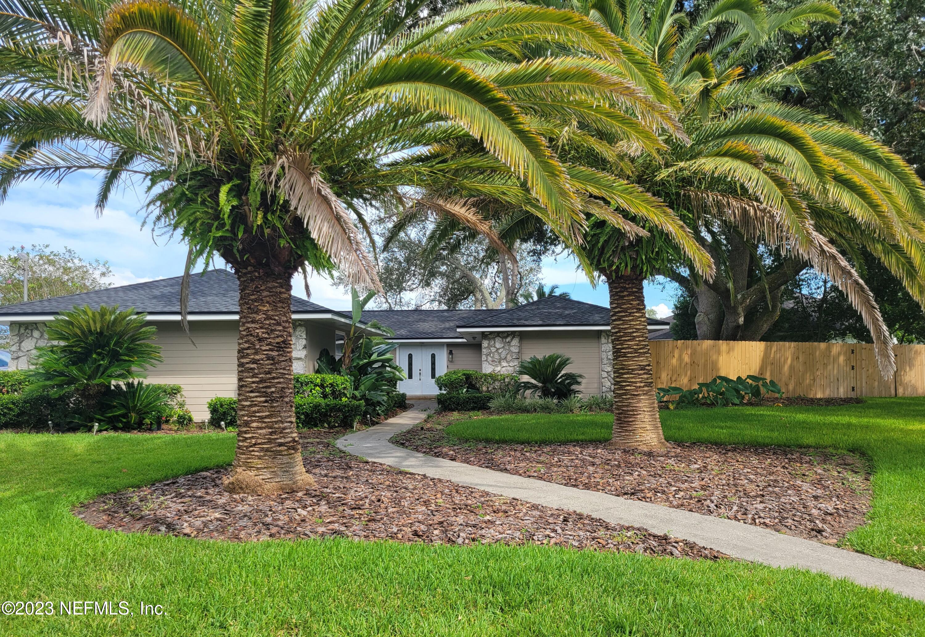 14340 Stacey Road Jacksonville, FL 32250 - Photo 1 of 54 a front view of a house with garden