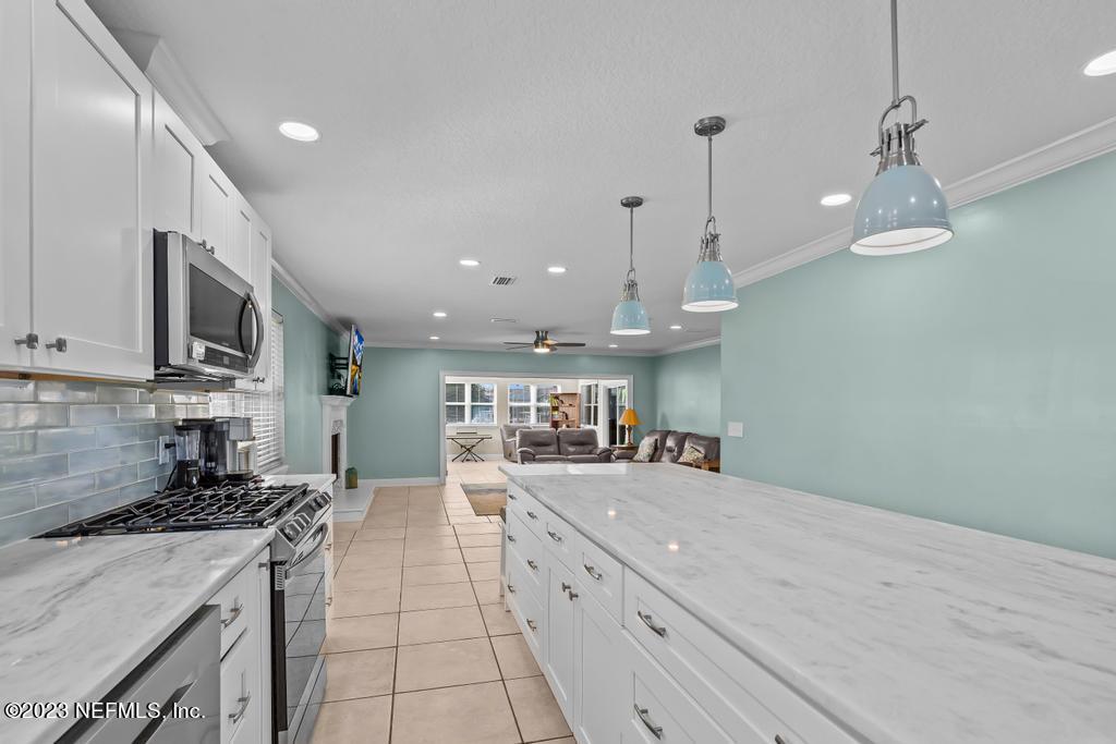14340 Stacey Road Jacksonville, FL 32250 - Photo 13 of 54 a large kitchen with stainless steel appliances granite countertop a sink a stove and a refrigerator