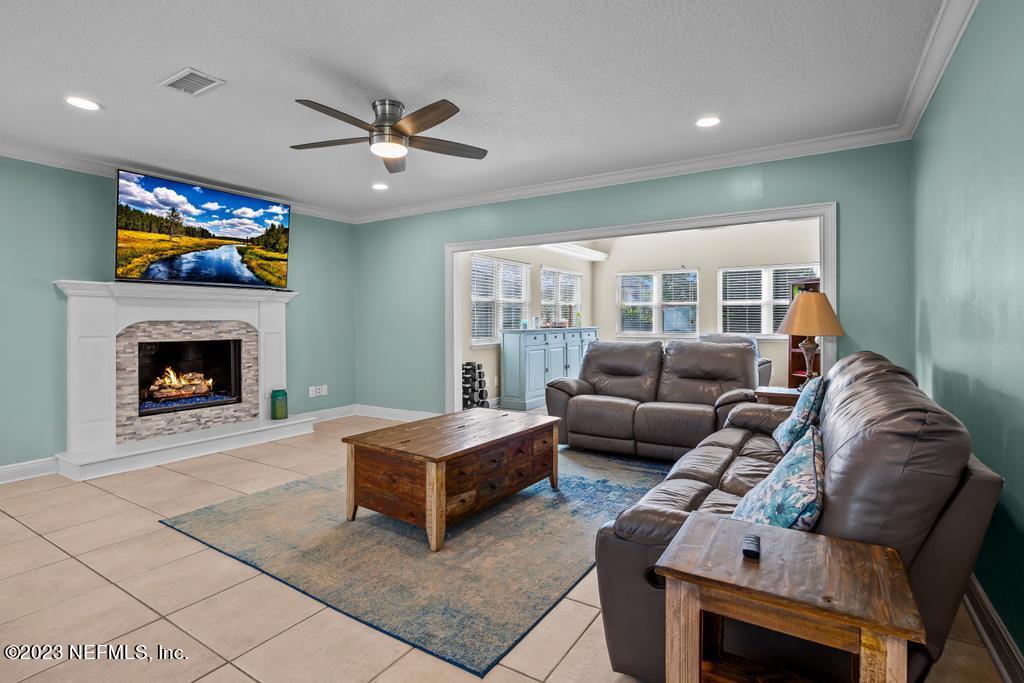 14340 Stacey Road Jacksonville, FL 32250 - Photo 15 of 54 a living room with furniture a flat screen tv and a fireplace
