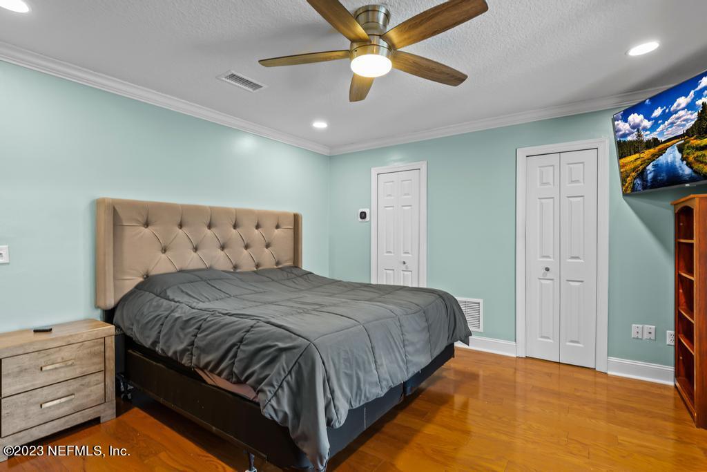 14340 Stacey Road Jacksonville, FL 32250 - Photo 21 of 54 a bedroom with a bed and a ceiling fan