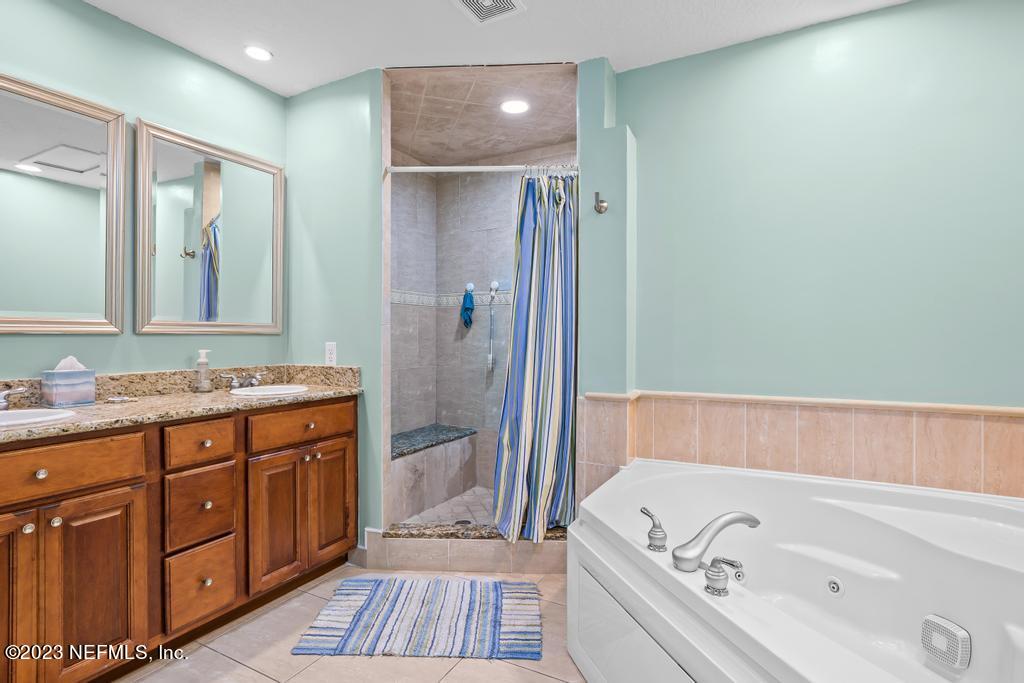14340 Stacey Road Jacksonville, FL 32250 - Photo 23 of 54 a bathroom with a tub sink and mirror