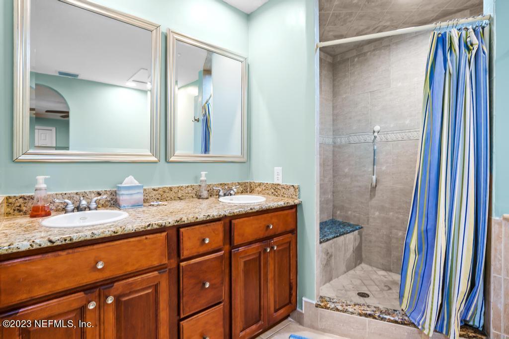 14340 Stacey Road Jacksonville, FL 32250 - Photo 25 of 54 a bathroom with a granite countertop sink and a mirror