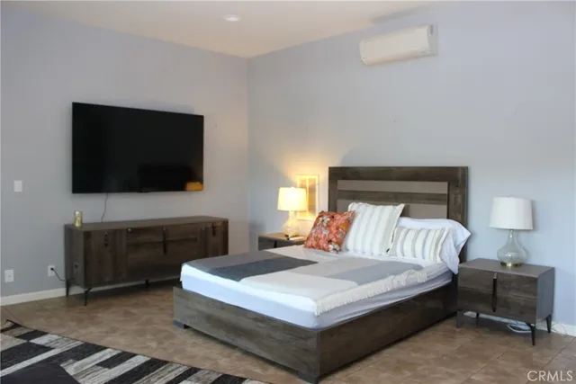 a bedroom with a bed and a flat screen tv