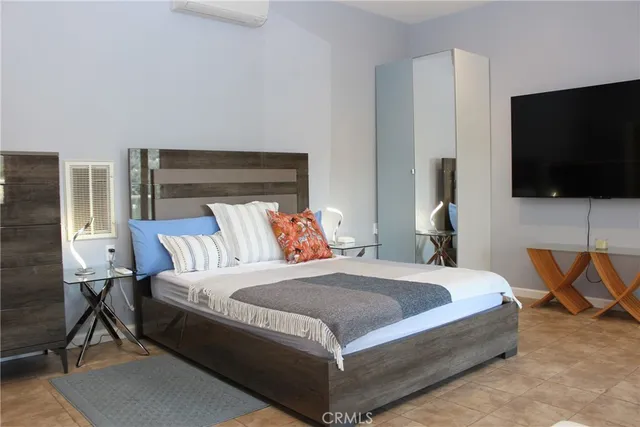 a bedroom with a bed and a flat screen tv