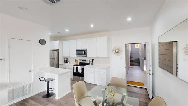 a living room with furniture a flat screen tv and a refrigerator