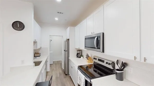 a kitchen with stainless steel appliances a stove a microwave and a refrigerator