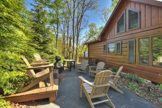 a view of a house with a small deck and a large tree