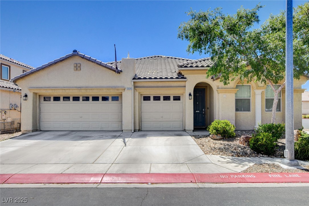 Mediterranean / spanish-style home featuring a garage, concrete driveway, stucco siding, and a tiled roof