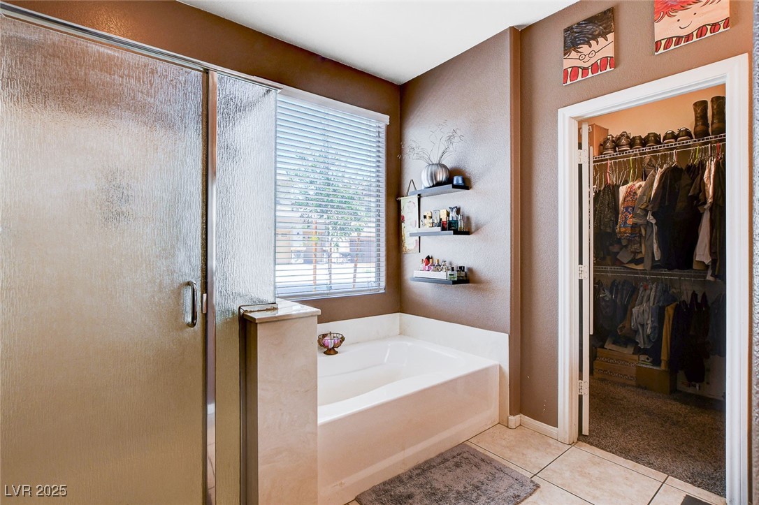 5929 North Caddy Ridge Street North Las Vegas, NV 89031 - Photo 20 of 37 Bathroom featuring a bath, a shower stall, tile patterned floors, and a spacious closet