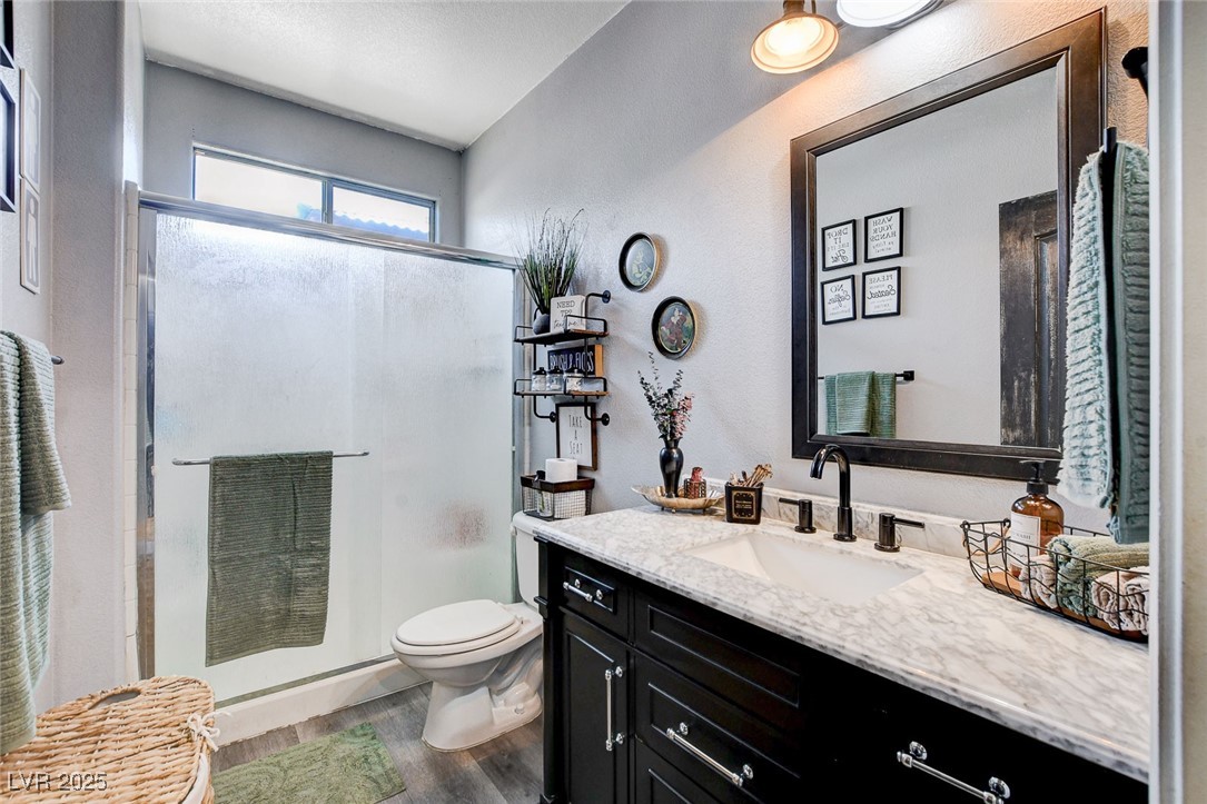 5929 North Caddy Ridge Street North Las Vegas, NV 89031 - Photo 24 of 37 Full bath featuring vanity, a shower stall, and wood finished floors