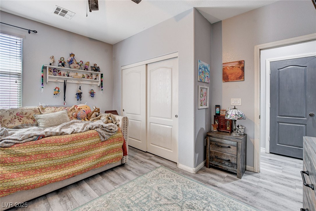 5929 North Caddy Ridge Street North Las Vegas, NV 89031 - Photo 27 of 37 Bedroom featuring a closet, light wood finished floors, and a ceiling fan