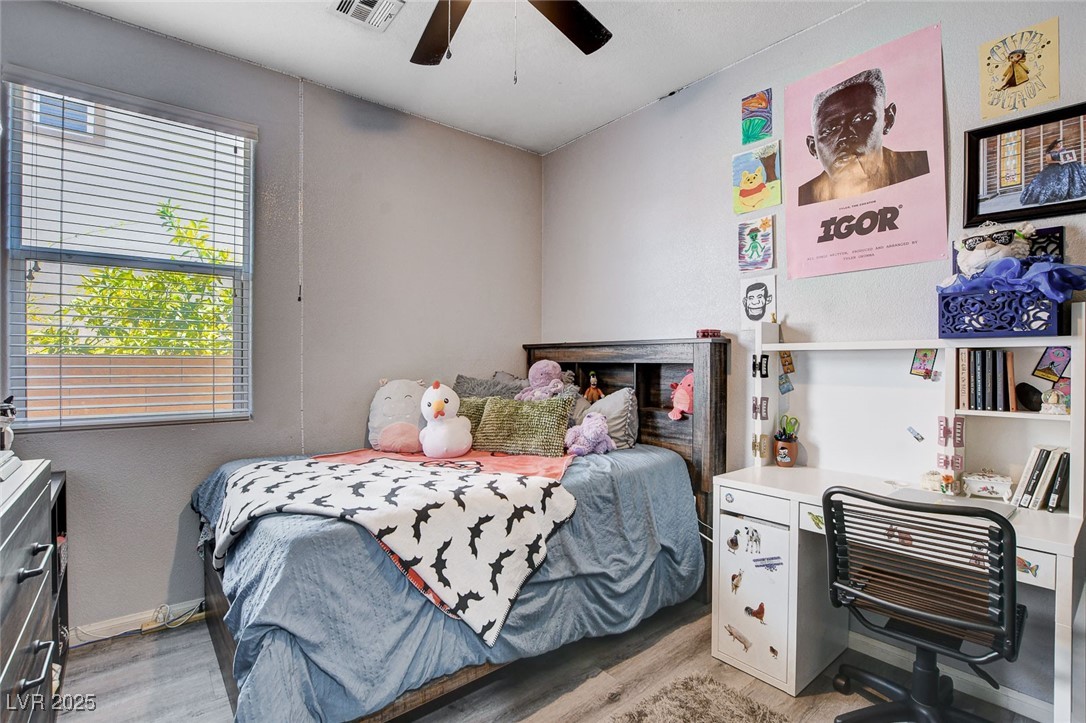 5929 North Caddy Ridge Street North Las Vegas, NV 89031 - Photo 28 of 37 Bedroom featuring light wood-type flooring, ceiling fan, an office area, and a textured wall