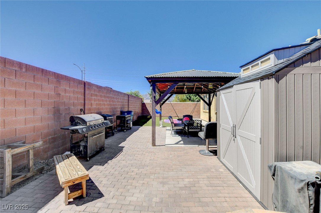 5929 North Caddy Ridge Street North Las Vegas, NV 89031 - Photo 33 of 37 Fenced backyard featuring a patio area, a storage shed, a grill, and a gazebo