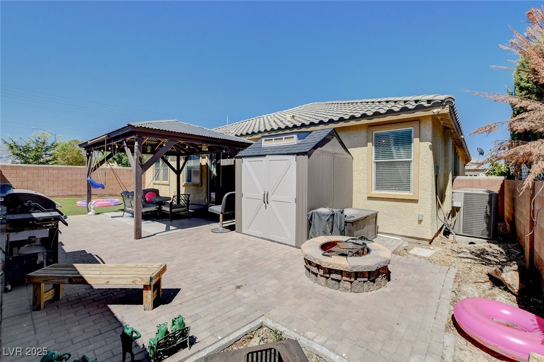 5929 North Caddy Ridge Street North Las Vegas, NV 89031 - Photo 34 of 37 Fenced backyard featuring a fire pit, a gazebo, a shed, grilling area, and a patio area