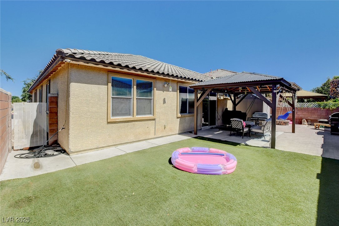 5929 North Caddy Ridge Street North Las Vegas, NV 89031 - Photo 35 of 37 Rear view of property featuring a fenced backyard, stucco siding, a patio, and a gazebo