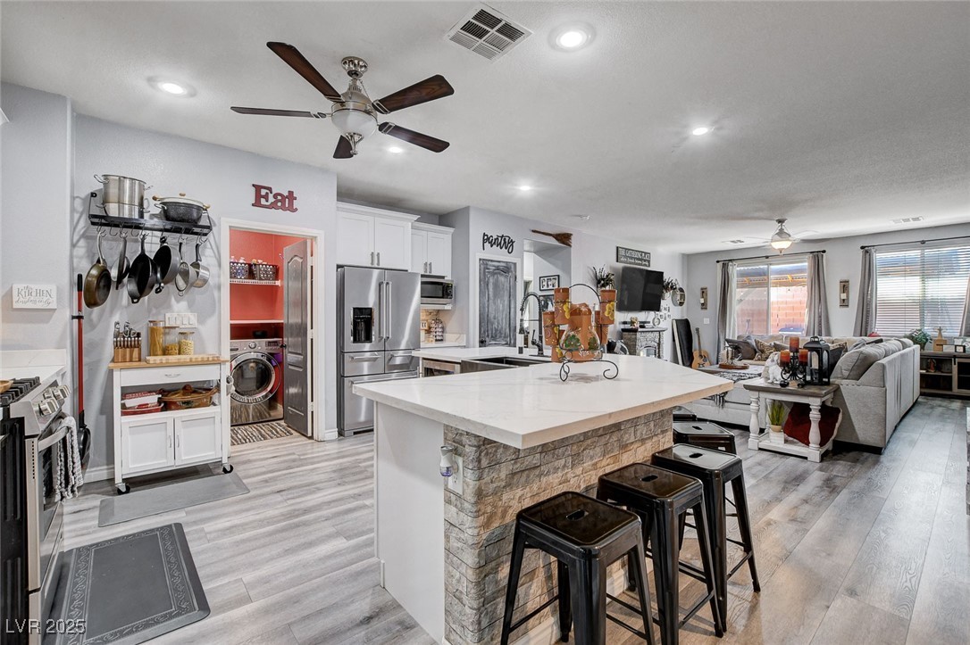 5929 North Caddy Ridge Street North Las Vegas, NV 89031 - Photo 9 of 37 Kitchen with a ceiling fan, stainless steel appliances, a breakfast bar area, light wood-style flooring, and recessed lighting