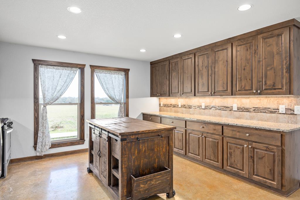 5025 Highway 16 Bandera, TX 78003 - Photo 14 of 49 a kitchen that has a sink a stove and wooden cabinets