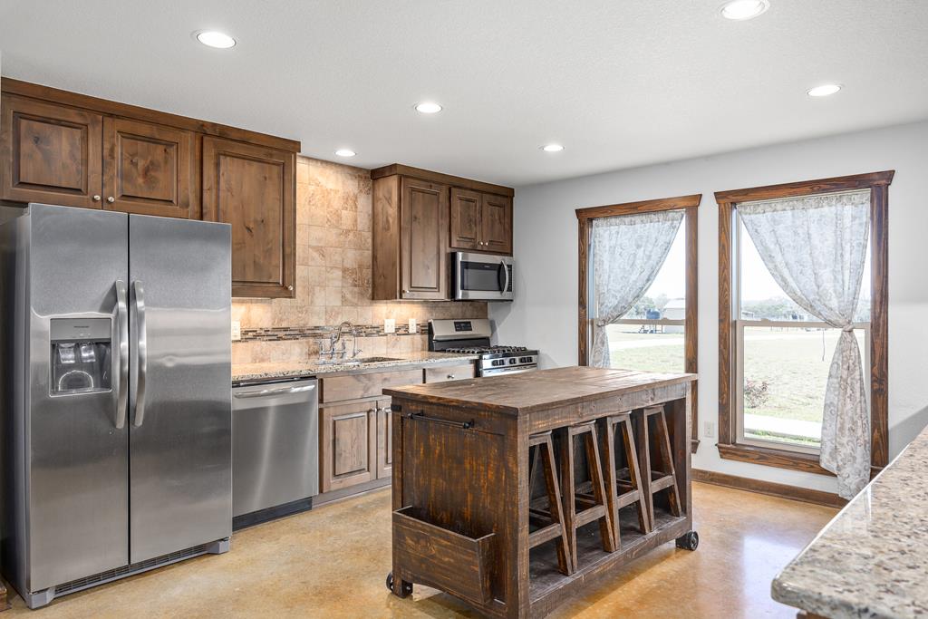 5025 Highway 16 Bandera, TX 78003 - Photo 15 of 49 a kitchen with stainless steel appliances granite countertop a stove a sink a refrigerator and island
