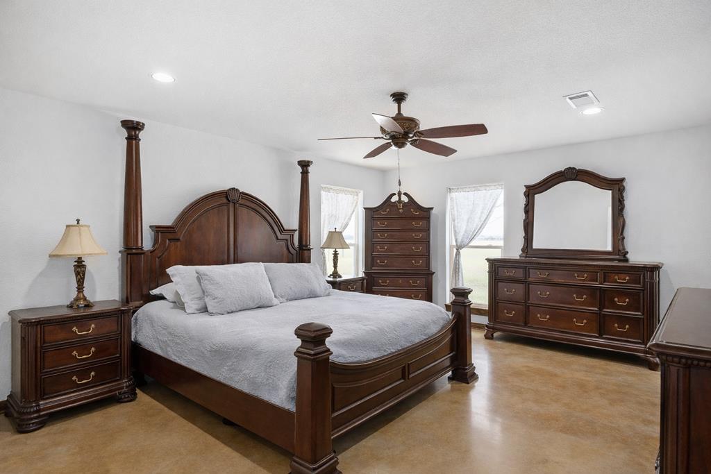 5025 Highway 16 Bandera, TX 78003 - Photo 16 of 49 a bedroom with a bed a dresser and a flat tv screen