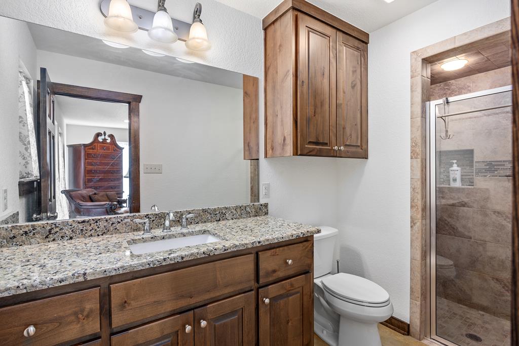 5025 Highway 16 Bandera, TX 78003 - Photo 17 of 49 a bathroom with a granite countertop sink toilet and mirror