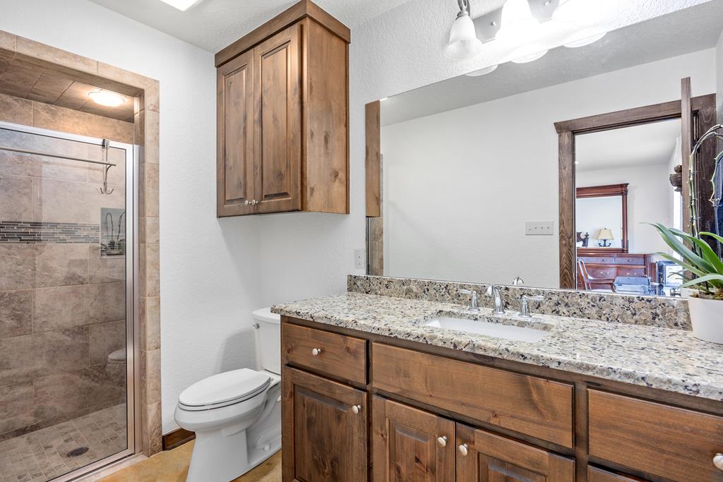 5025 Highway 16 Bandera, TX 78003 - Photo 21 of 49 a bathroom with a granite countertop sink toilet and shower