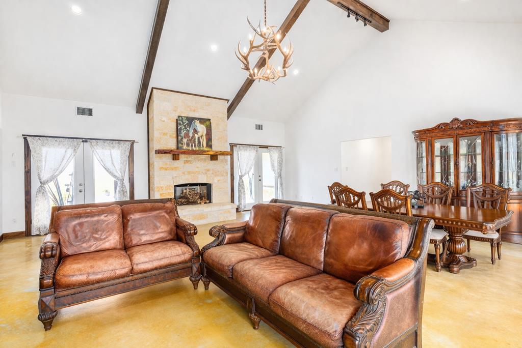 5025 Highway 16 Bandera, TX 78003 - Photo 10 of 49 a living room with furniture a fireplace and a chandelier