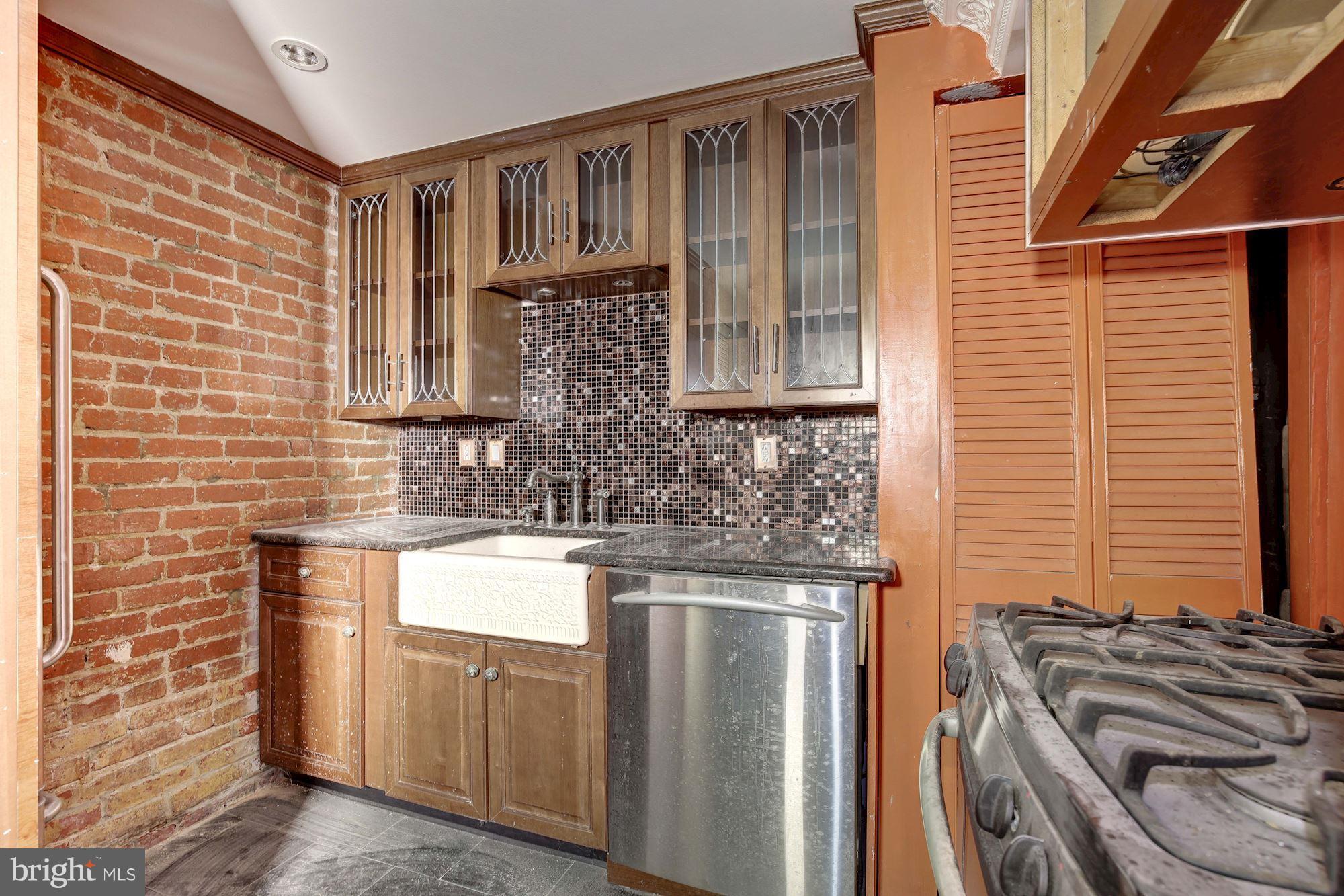 87 V Street Northwest Washington, DC 20001 - Photo 28 of 30 a kitchen with stainless steel appliances granite countertop a sink stove and cabinets