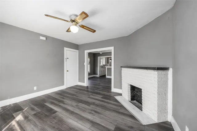 a view of empty room with wooden floor and ceiling fan