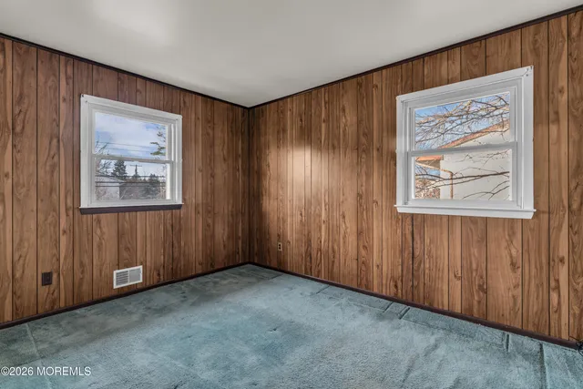 an empty room with windows and closet area