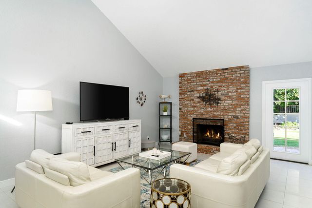 a living room with furniture a fireplace and a flat screen tv